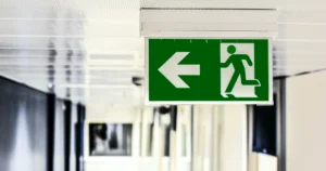 pictogram nooduitgang op groene achtergrond boven een deur